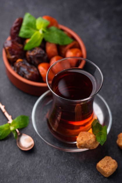 Turkish tea in traditional glass with dried fruits