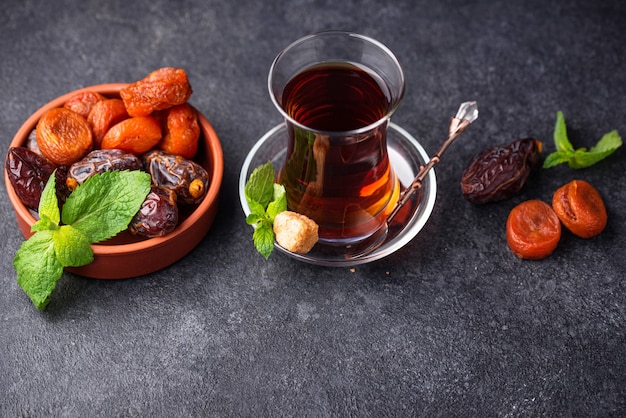 Turkish tea in traditional glass with dried fruits