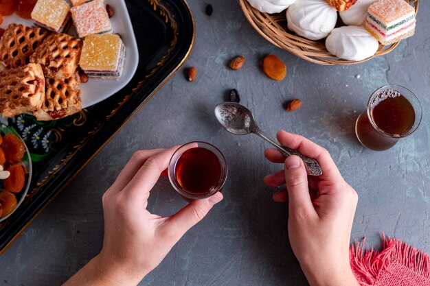 Turkish tea in traditional glass with sweets, dried fruits and nuts for a teatime. Top view