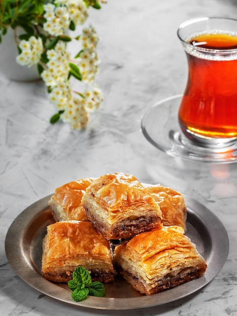 Turks dessert Baklava met walnoten en hazelnoten en zwarte sterke Turkse thee