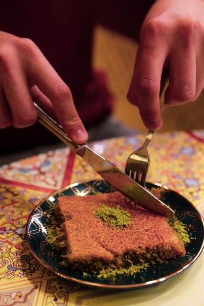 Turks dessert kunefe, kunafa, kadayif met pistachepoeder en kaas heet een snoepje gegeten