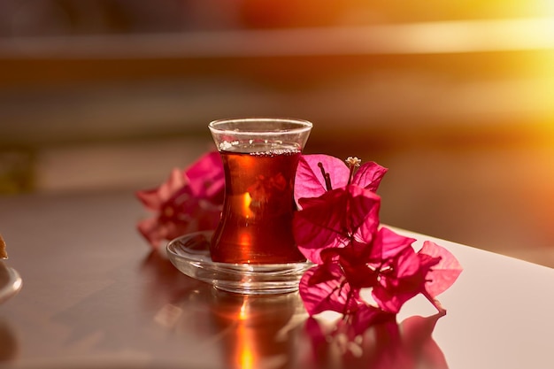 Turks fruit en traditioneel glas turkse thee met bougainvillea bloemen romantisch diner concept ontspannend kalmerend drankje reizen turkije concept helder ontspannend drankje foto van hoge kwaliteit