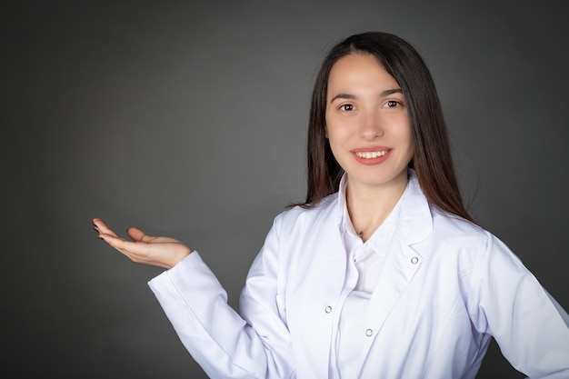 Turks mooi glimlachend jong meisje in dokters- of chef-kokkleding en lege lade pose