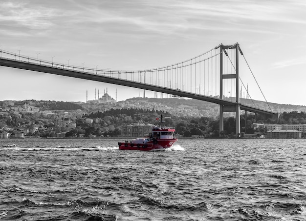 Turks schip onder de bosporus-brug van istanbul, vintage stijl.