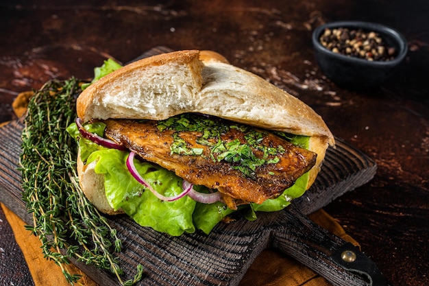 Turks street food balik ekmek vissandwich met gegrilde makreelfilet in een broodje donkere achtergrond bovenaanzicht