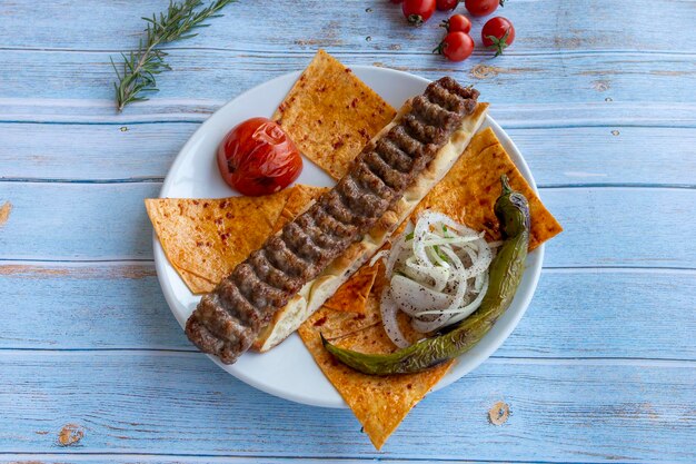 Foto turkse adana kebab met groenten op de plaat