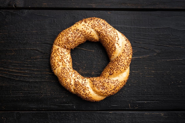 Turkse bagel Simit met sesam op zwarte houten tafel achtergrond bovenaanzicht plat lag met kopieerruimte voor tekst