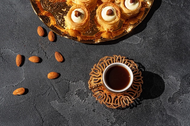 Turkse dessert baklava met een kopje koffie op zwarte achtergrond