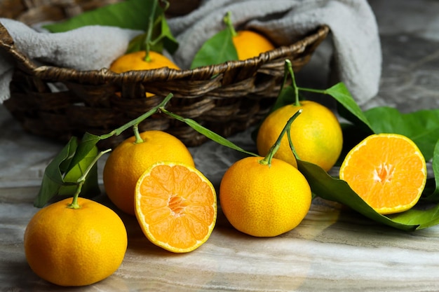 Turkse geelgroene mandarijnen geïsoleerd op marmeren tafel met een mand verse rijpe mandarijnen