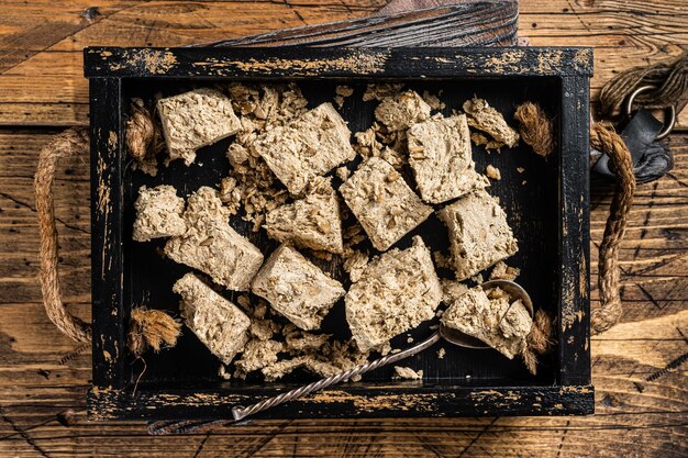 Turkse Halva met zonnebloempitten en honing in houten dienblad. Houten achtergrond. Bovenaanzicht.