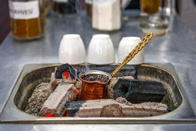 Turkse koffie koken op kolen op een traditionele manier Mobiele coffeeshop op straat close-up