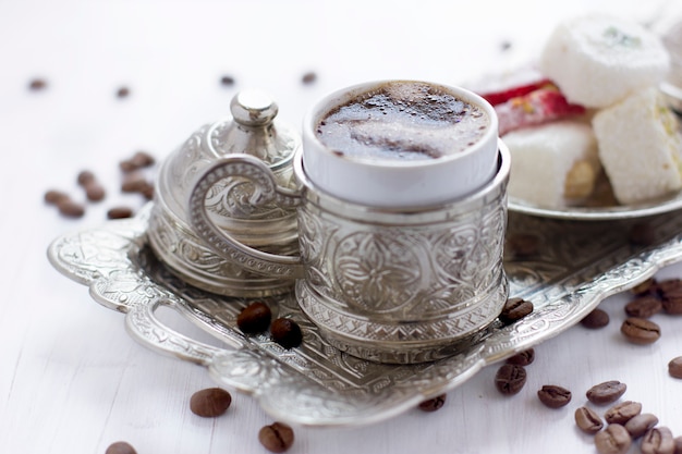 Foto turkse koffie met traditionele turkse snoepjes in zilveren mok