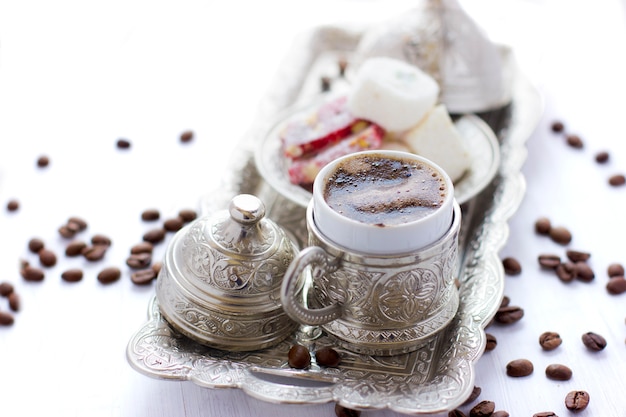 Turkse koffie met traditionele Turkse snoepjes in zilveren mok