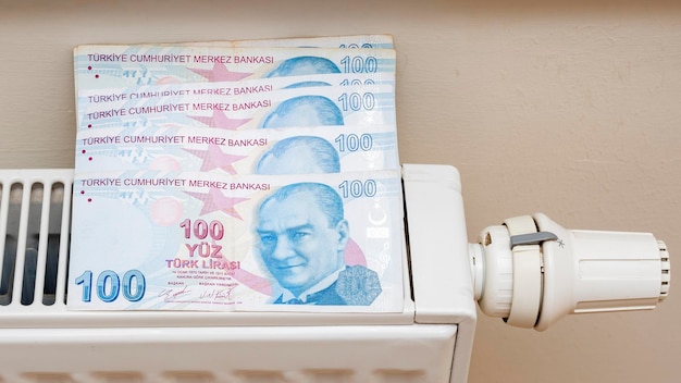 Turkse lira bankbiljetten in een centrale verwarming radiator het concept van dure stookkosten