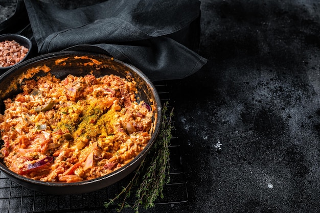 Turkse Menemen-omelet in een koekenpan Zwarte achtergrond Bovenaanzicht Kopieer ruimte