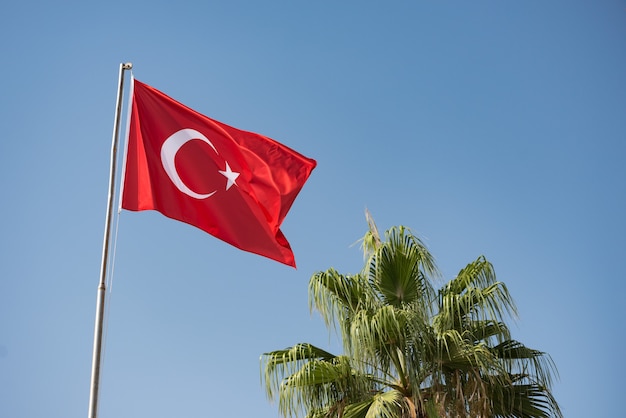 Turkse vlag zwaaien in de wind tegen de blauwe lucht