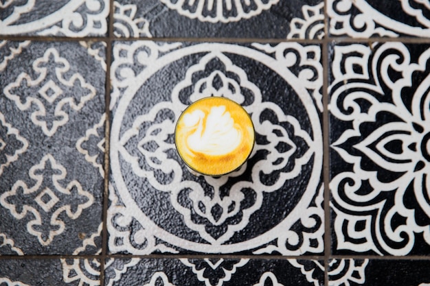 Turmeric latte on ornamental floor background