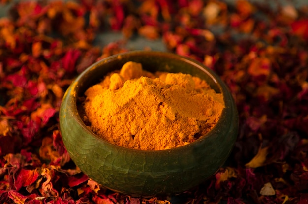 Turmeric powder in a boul with wooden spoon