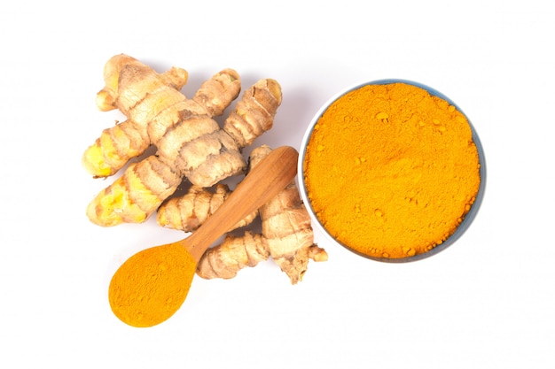 흰색 배경에 갈색 그릇에 심 황 가루 (Curcuma). 약초