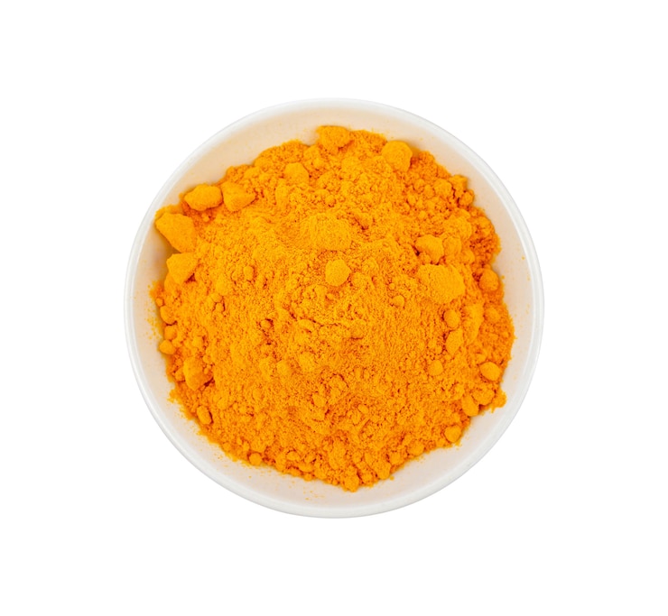 Photo turmeric powder in white ceramic bowl on white. top view