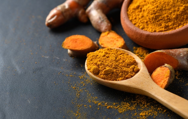 turmeric powder in wood spoon 