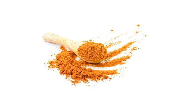 Turmeric powder in a wooden spoon on white background