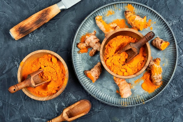 Turmeric root and powder ground spice on a concrete kitchen table Condiment Top view