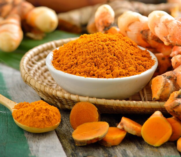 Turmeric roots in the basket on wooden table