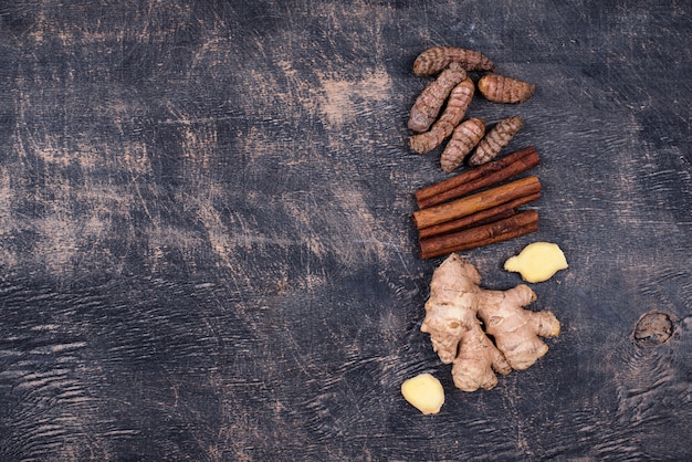 Turmeric roots, cinnamon and ginger background