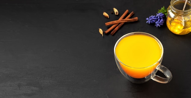 Turmeric and spices herbal tea on a black surface