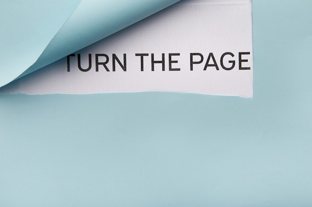 Photo turn the page text appearing behind torn blue paper, top view. new lofe and opportunities concept, copy space
