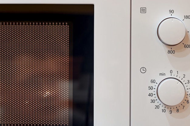 Turned on classic microwave oven. Closeup.