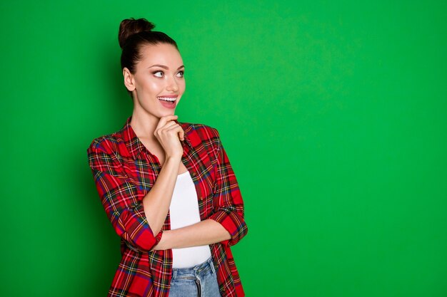 Turned photo of positive cheerful girl touch chin fingers look copyspace think thoughts enjoy summer holiday plan wear checked shirt isolated over shine color background