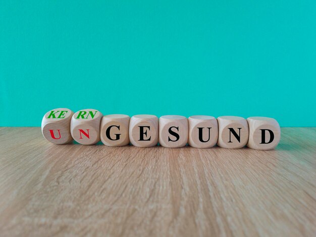 Photo turned wooden cubes and changes the german word ungesund to kerngesund beautiful gray table