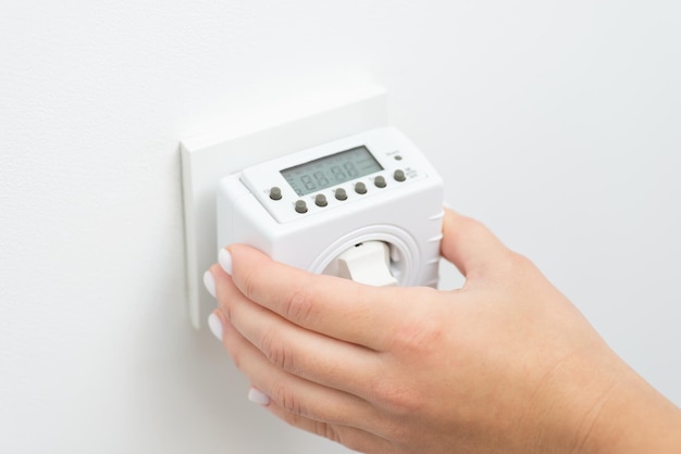 Turning on outlet computer that counts and saves energy turns on and off socket Plug in the controller of electricity into European socket