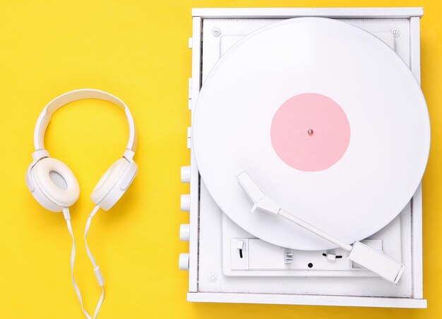 사진 턴테이블 비닐 레코드 플레이어 및 노란색 배경의 헤드폰 dj가 음악을 믹싱하고 재생하는 사운드 기술 흰색 비닐 레코드 미니멀리즘 플랫 레이 탑 뷰