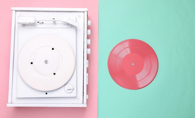 Turntable vinyl record player on pink blue background Sound technology for DJ to mix and play music White vinyl record Flat lay Top view