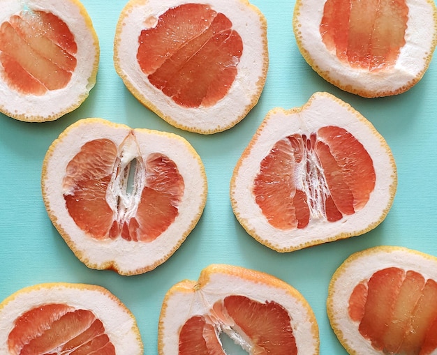 Foto turquoise achtergrond met schijfjes grapefruit