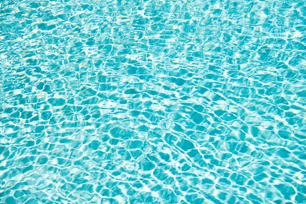Бирюзовый цвет фона воды бассейна с рябью на летних каникулах
