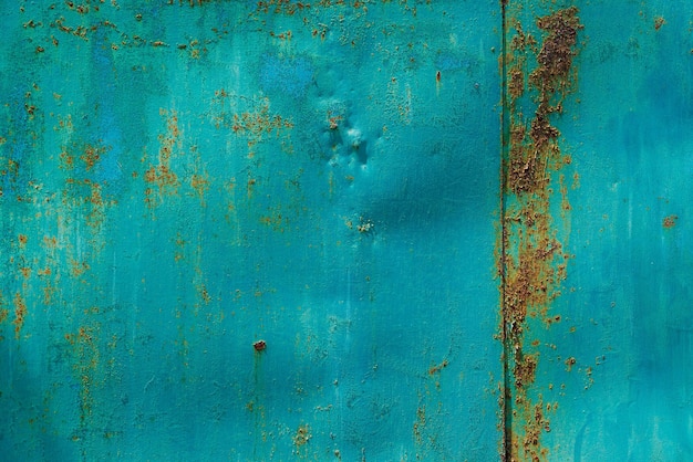 Turquoise geschilderd geslagen stalen oppervlak met vlekken van roest fullframe achtergrond en textuur