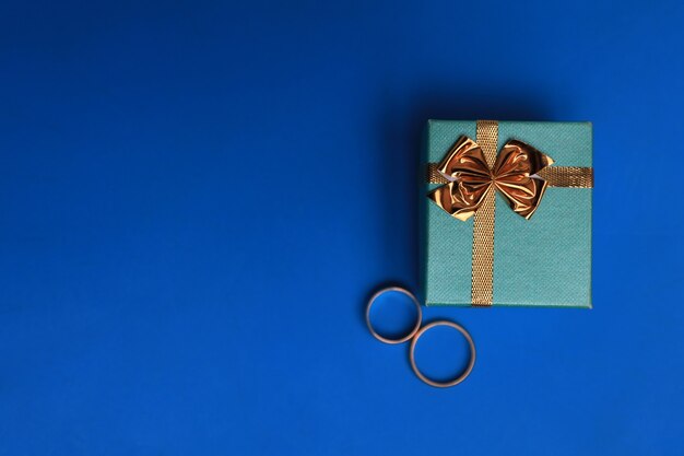 Turquoise gift box with rings on blue