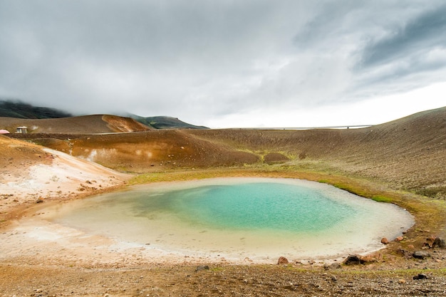 Бирюзовый пруд в минерально-оранжевом районе недалеко от Вити в районе вулкана Крафла в Исландии.