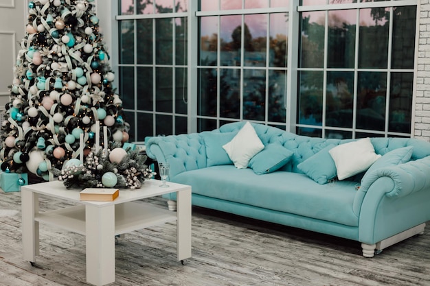 Turquoise sofa in the New Years room with a large window