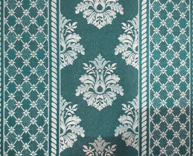 A turquoise and white wallpaper with a floral pattern.