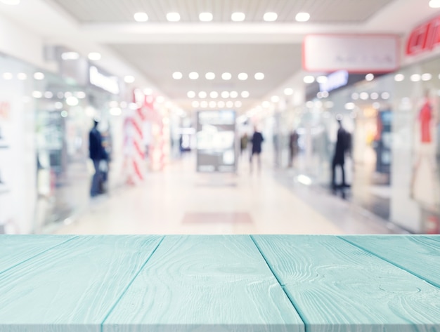 Turquoise wooden table in front of shopping mall