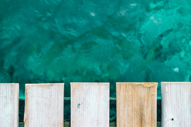 turquoise zee en houten pier. Selectieve focus op een houten pier en donkerblauwe, donkergroene zee.