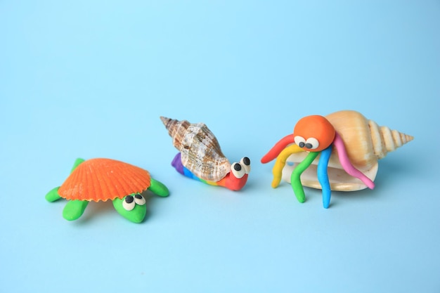 Turtle snail and crab made from plasticine on light blue background Children's handmade ideas