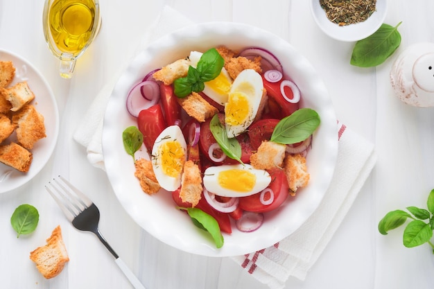 Tuscan panzanella salad fresh tomatoes salad with basil leaves
eggs olive oil and onion in white bowl on light background
vegetarian panzanella salad mediterranean healthy food top
view