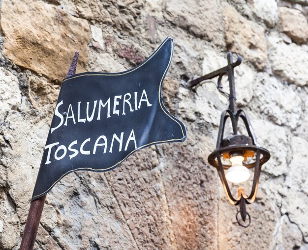 Toscana, italia. streetsign tradizionale macelleria su un vecchio muro