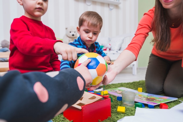 Tutor e bambini che giocano a palla